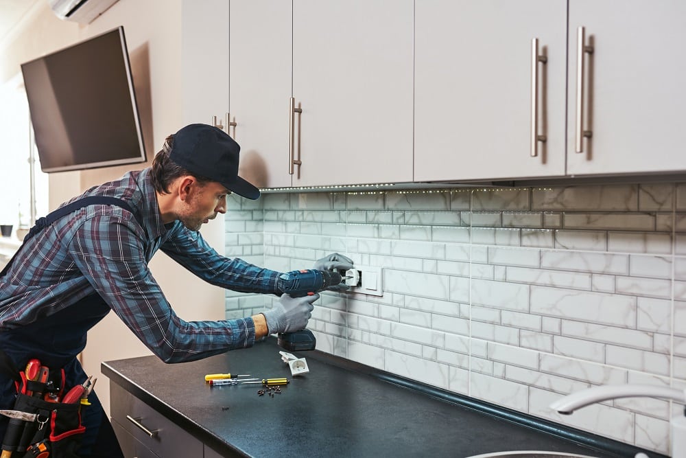 electricity protection. side view of young handyman with perforator